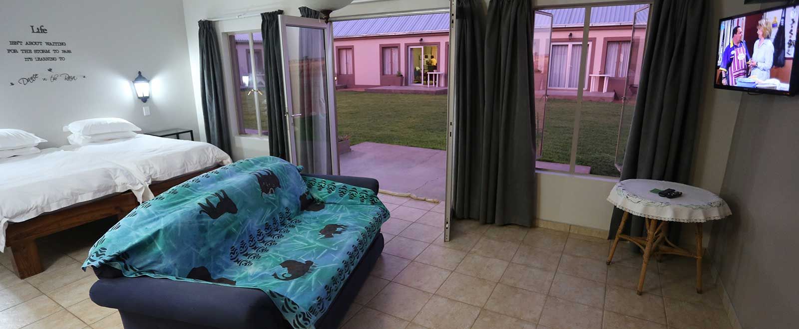 Family room with beds, couch and sliding door onto the lawn